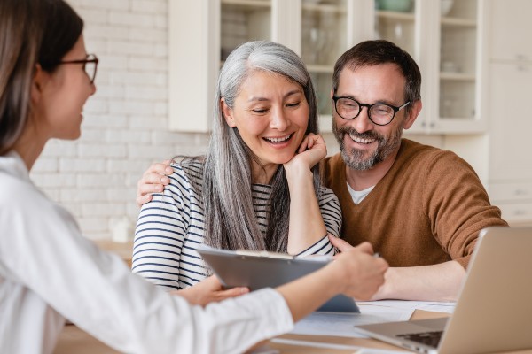 Couple looking at retirement plan with business woman